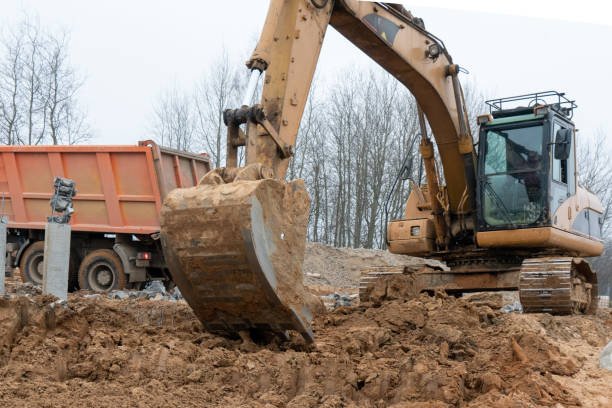 yellow mini excavator digging a trench
